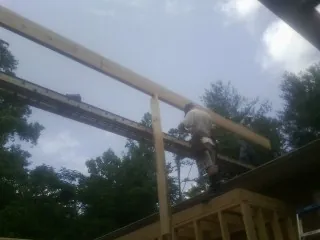 Carpenter setting a ridge beam over a new addition frame — Ice Dam Removal by Roofing Brothers in Kirkwood